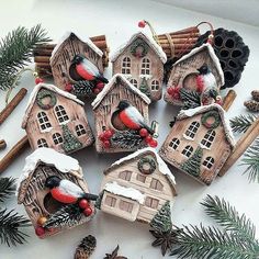 small bird houses are decorated with pine cones and red berries on the top, along with other decorations