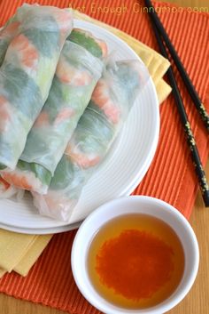 some food is sitting on a plate with chopsticks next to it and a bowl of soup