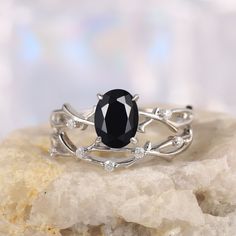 a black diamond ring sitting on top of a rock