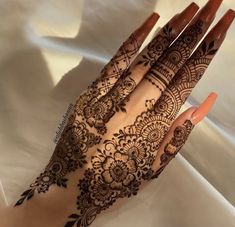 a woman's hand with henna tattoos on it