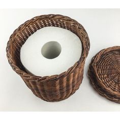 two wicker baskets next to each other with a white candle in the middle one