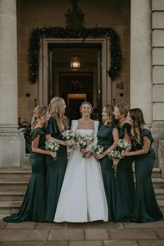 the bride and her bridesmaids are standing in front of an old building