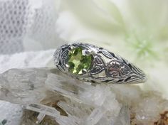 Natural Peridot Ring Etched Wedding Design#160 Made To Order Here we have a Victorian/Edwardian reproduction ring in sterling silver with a stunning natural peridot gemstone. This full cut round peridot gem is 6mm in diameter. The inside of the band is marked 925 for sterling. Notice the beautiful floral design of the silver filigree setting and band. This is a lovely rendition of an Antique filigree ring; and it is ready to wear. A gift ring box is included and all rings are shipped in the box Green Engraved Wedding Rings, Wedding Ring With Hallmarked Peridot, Ornate Green Wedding Ring, Vintage Peridot Rings For Wedding, Fairy Rings, Garnet Wedding Rings, Filigree Ring Gold, Stock Design, Gemstone Art