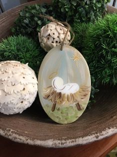 two ceramic ornaments sitting on top of a wooden table next to some plants and balls