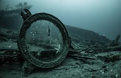 an old ship wreck in the ocean with water around it and debris on the ground