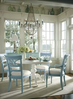 a dining room table with four chairs and a chandelier