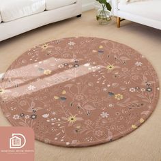 a round rug with flowers on it in a living room next to a white couch