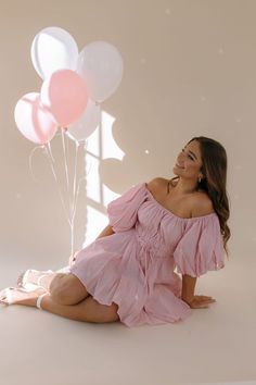 a woman sitting on the floor with balloons