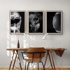 three black and white photographs hang on the wall above a wooden desk with a chair