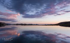 the sky is reflected in the calm water