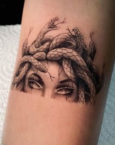 a woman's arm with a snake tattoo on it