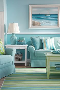 a living room filled with blue furniture and green accents on the walls, along with striped rugs