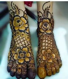 the feet and hands of a woman with henna designs on their legs, both decorated with flowers