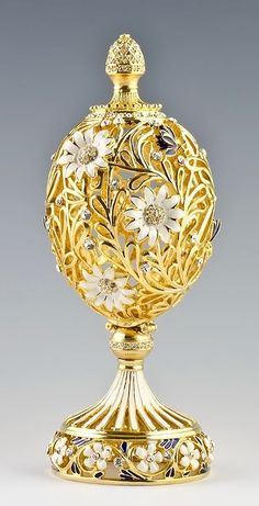 an ornate gold vase with flowers on it