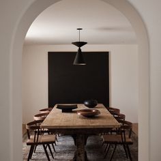 a dining room table with chairs and a blackboard in the background