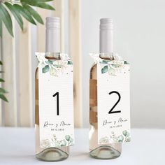 two wine bottles with the numbers one and two on them, sitting next to each other