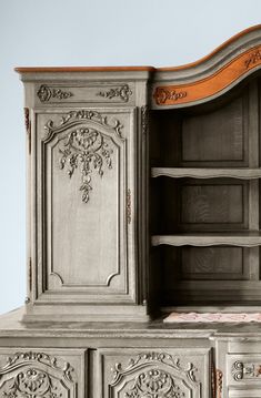 an old dresser with ornate carvings on the doors and drawers, painted in pale gray