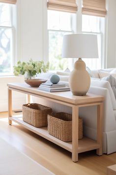 a living room with a couch, table and two baskets on the coffee table in front of it