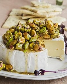 there is a piece of cheese with nuts on it and crackers next to it