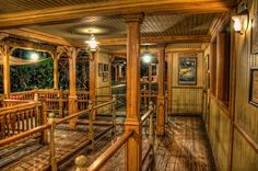 the inside of a house with wood floors and wooden railings on either side of the porch