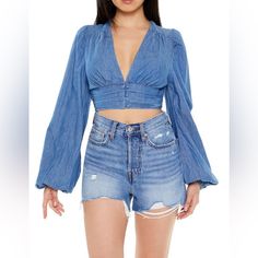 New With Tags. A Denim Crop Top Featuring A Plunging Neckline, Long Bell Sleeves, And A Pintucked Hem With Tonal Buttons. Size Small. Zero Stretch. Not Big Bust Friendly. I’m A 34 C & The Top Wouldn’t Button For Me . Content + Care - 100% Cotton - Machine Wash Cold Size + Fit - Model Is 5'6" And Wearing A Small Trendy Denim V-neck Top, Medium Wash Denim V-neck Top, Trendy Denim Tops For Day Out, Fitted Denim Blue Top For Day Out, Medium Wash Cropped Tops For Spring, Trendy Dark Wash Denim Blouse, Medium Wash Denim Tops For Day Out, Dark Wash Denim Tops For Spring, Trendy Denim Blue V-neck Top