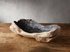 a wooden bowl sitting on top of a wooden table