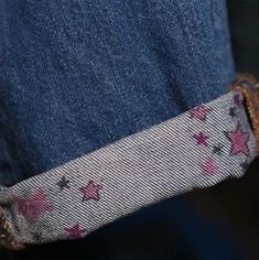 someone is holding something in their pocket with pink stars on the bottom and blue jeans