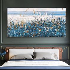 a painting on the wall above a bed in a room with blue and white decor