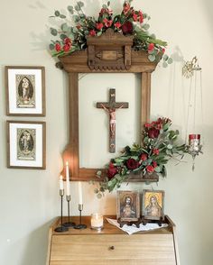 an altar with flowers, candles and pictures hanging on the wall above it in a home