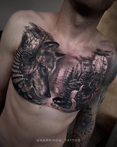 a man's chest with a wolf and forest scene tattoo on his chest is shown