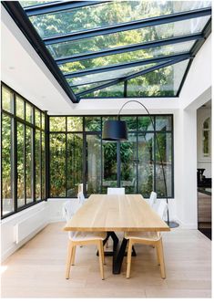 a dining room with a table and chairs under a glass roof