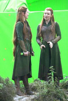 two women dressed in medieval clothing standing next to each other on a green screen background