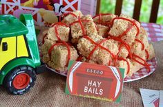 a table topped with a plate of food next to a toy tractor and box of hay balls