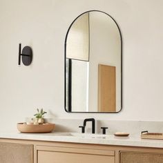 a bathroom sink with a mirror above it and a wooden bowl on the counter top