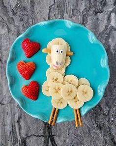 a plate topped with bananas and strawberries on top of a blue plate covered in fruit