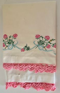 three pieces of white cloth with pink flowers on them