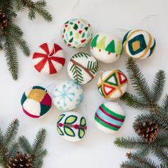 some ornaments are sitting on the table next to pine cones