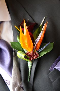 a boutonniere with orange and red flowers on it's lapel