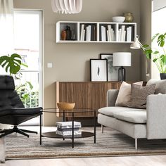 a living room filled with furniture and bookshelves next to a large open window