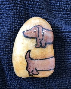 a rock with a drawing of a dachshund sitting on top of it