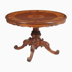 an antique wooden table with ornate carvings on the top and legs, against a white background