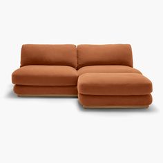 an orange couch with a footstool sitting on top of the backrests