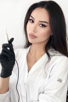 a woman with long hair and gloves holding a syringe in her right hand