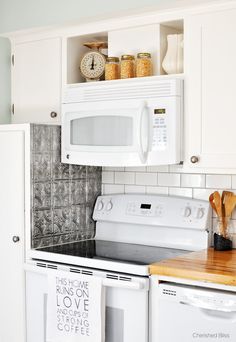 a white stove top oven sitting inside of a kitchen next to a wooden cutting board