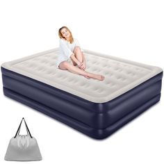 a woman sitting on top of an inflatable mattress next to a white bag