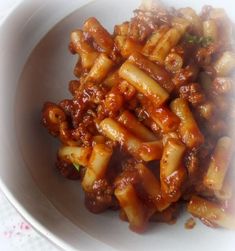 a white bowl filled with pasta covered in sauce