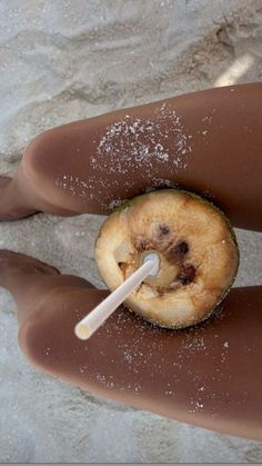 a person's legs covered in powdered sugar and an apple on the beach