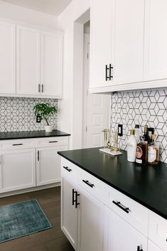 a kitchen with white cabinets and black counter tops is seen in this image from the front