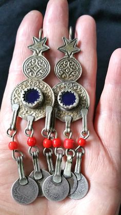 "Old Moroccan Berber silver enamel, blue glass and danglers with old coins earrings from South Morocco. The earrings have a blue glass stone in the center, 3 dangling pendants with red glass and old coins hanging down. There is some old gilt left in the center. Lovely easy to wear every day earrings for stretched ears only!! These earrings have a good size and weight to be worn. The ear wires are thicker than by Western ears, they are 1,5 mm = 14 Gauge. Length is 10,5 cm (3.4\") Weight is 40 gra Vintage Blue Earrings For Festival, Traditional Blue Pendant Earrings, Traditional Blue Nickel-free Jewelry, Hamsa Pendant, Coin Earrings, Carnelian Beads, Stretched Ears, Old Coins, Metal Work