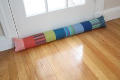 a multicolored pillow sitting on the floor in front of a door